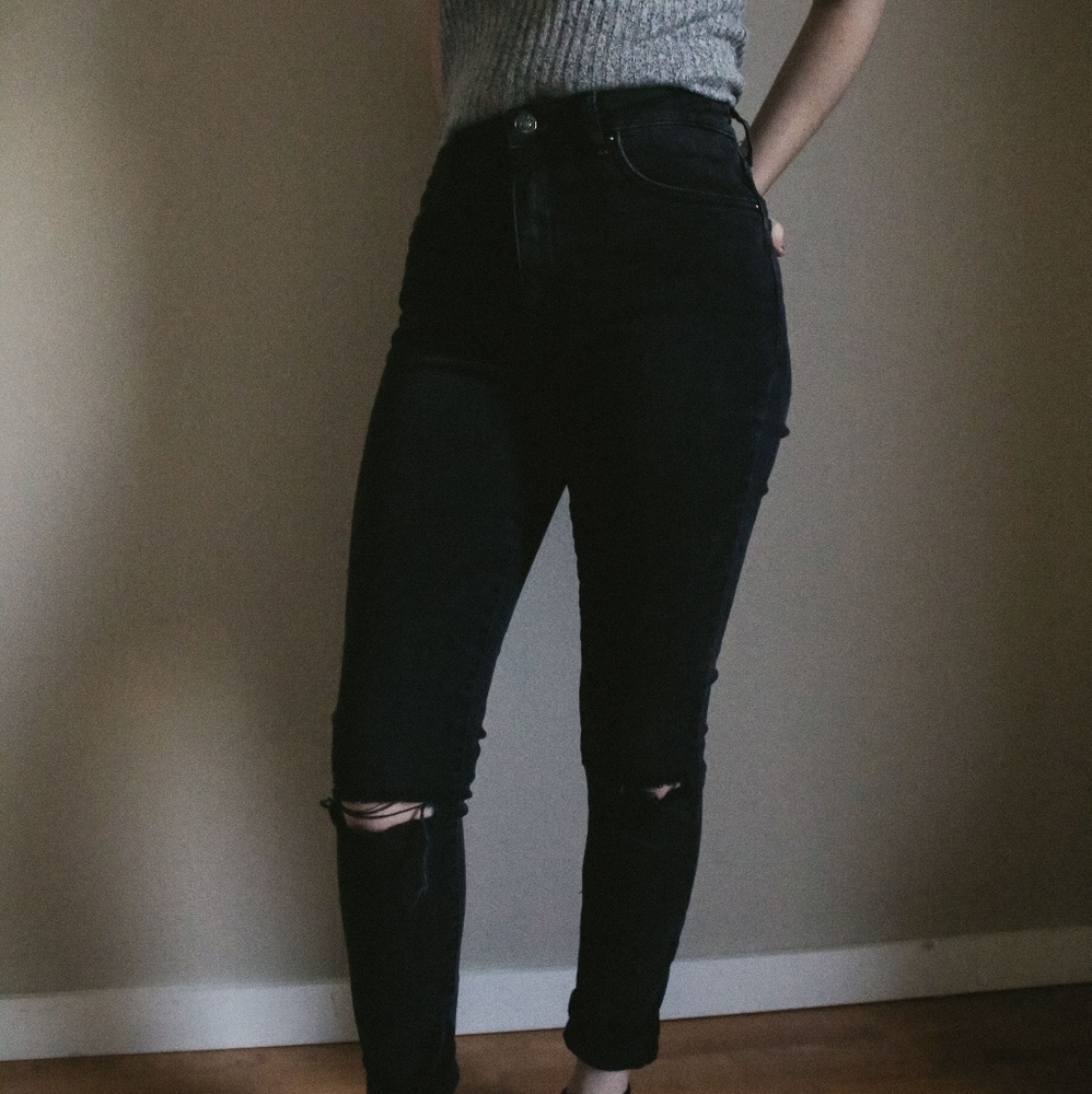 Black highwaisted jeans with rips in the knees